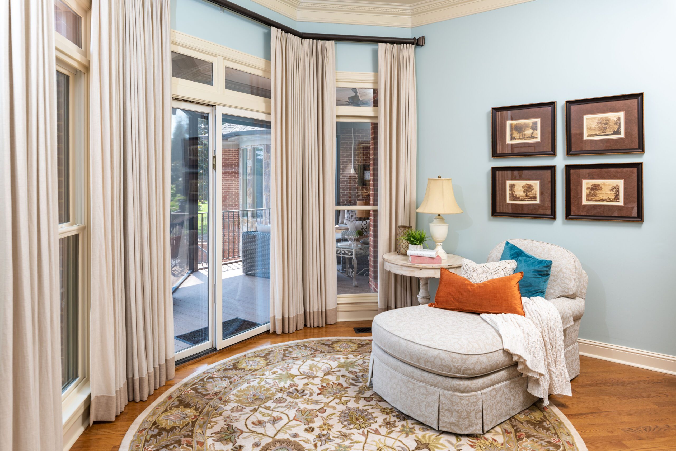 Cozy Chattanooga sitting nook staged for buyers, with custom window treatments framing large windows beside a chaise and lamp